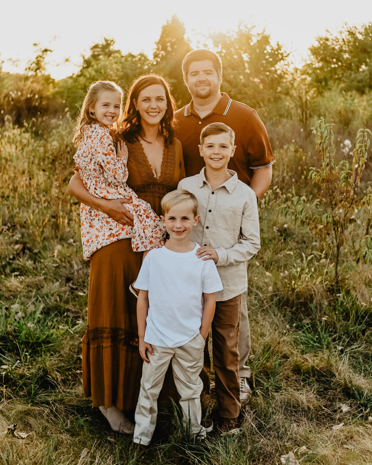 The Keepset family standing together in a field at golden hour.