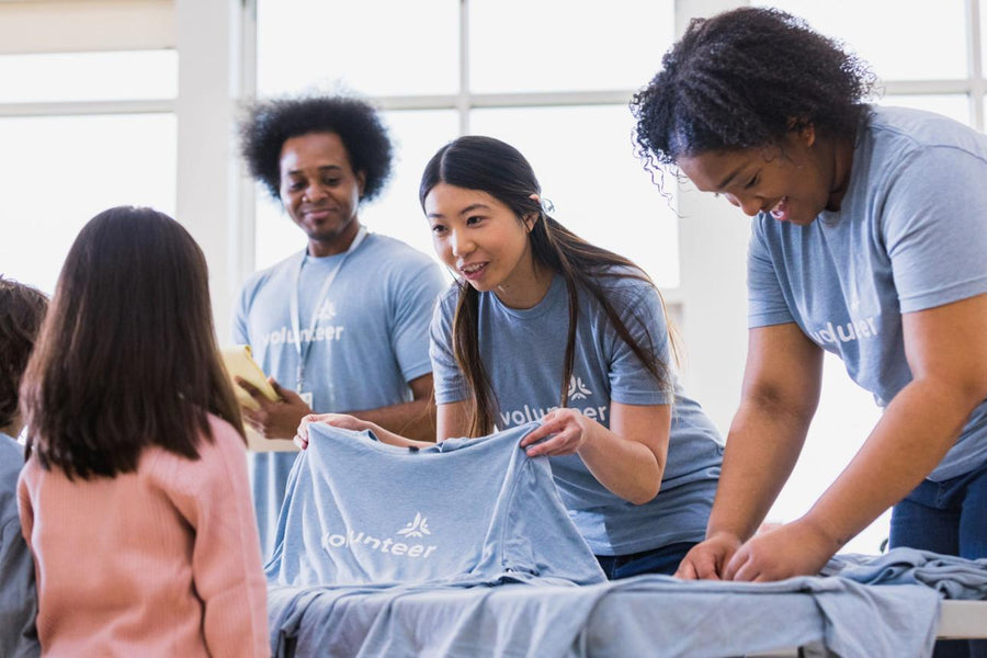 Volunteers in matching t-shirts handing one out at a community event