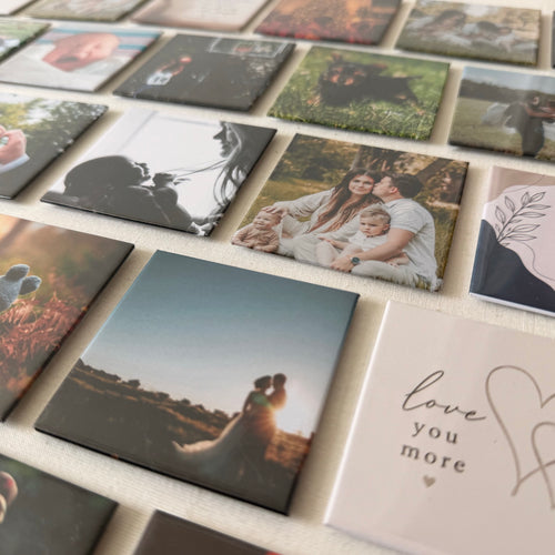 Dozens of finished photo magnets laid out in rows on cream linen, each carrying a different photograph.