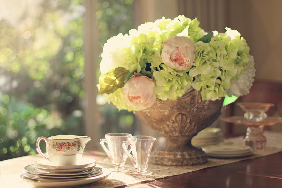 Hydrangeas and cream china on a table in window light