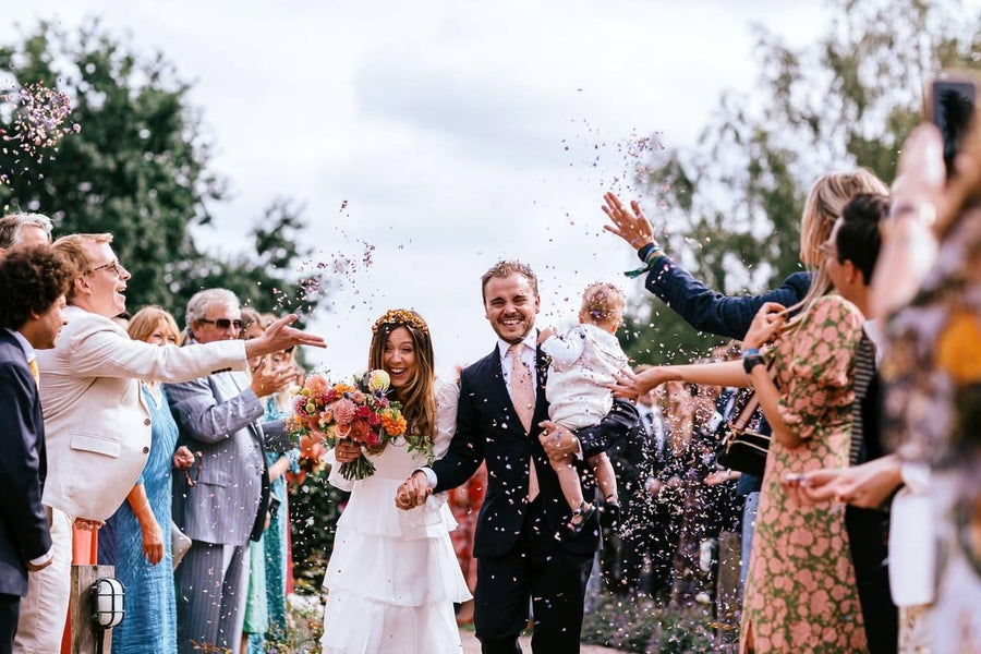 Guests throwing confetti over a couple leaving their wedding